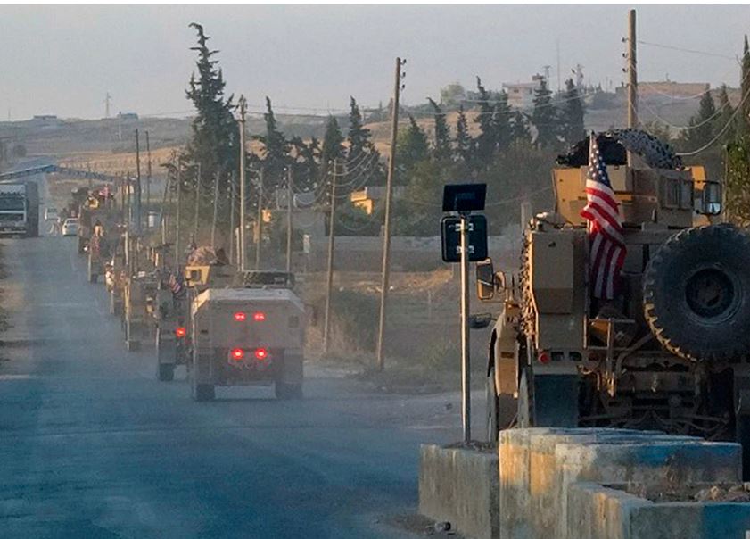 Американские военные машины едут по главной дороге на северо-востоке Сирии